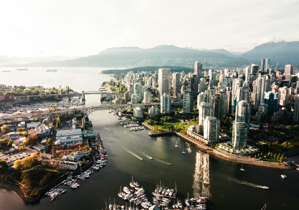 Aerial Shot of Vancouver with Tall Buildings, Ocean and Mountains in the background