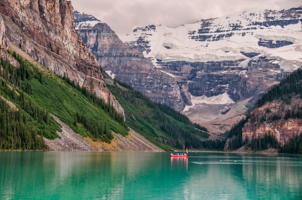 Red canoe in lake lousie with mountains in background